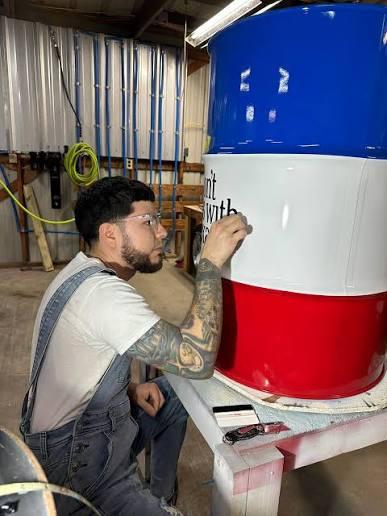 Texas Works Services team member hand-finishing a barrel