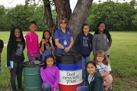 Students with a Texas Works Services barrel at a school